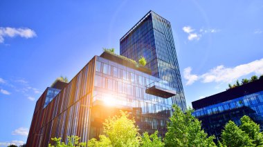 Karbondioksiti azaltmak için ağaçlı sürdürülebilir cam ofis binası. Modern şehirde çevre dostu bir bina. Yeşil çevresi olan bir ofis. Şirket binası CO2 'yi düşürdü.