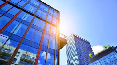 Mavi gökyüzüne karşı modern gökdelenlerin alt manzarası. Şehir merkezindeki iş binalarına bakıyorum..