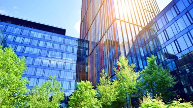 Karbondioksiti azaltmak için ağaçlı sürdürülebilir cam ofis binası. Modern şehirde çevre dostu bir bina. Yeşil çevresi olan bir ofis. Şirket binası CO2 'yi düşürdü.