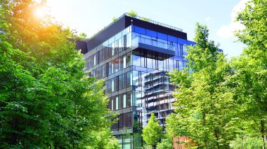 Karbondioksiti azaltmak için ağaçlı sürdürülebilir cam ofis binası. Modern şehirde çevre dostu bir bina. Yeşil çevresi olan bir ofis. Şirket binası CO2 'yi düşürdü.