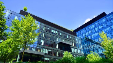 Karbondioksiti azaltmak için ağaçlı sürdürülebilir cam ofis binası. Modern şehirde çevre dostu bir bina. Yeşil çevresi olan bir ofis. Şirket binası CO2 'yi düşürdü.