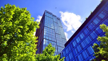 Karbondioksiti azaltmak için ağaçlı sürdürülebilir cam ofis binası. Modern şehirde çevre dostu bir bina. Yeşil çevresi olan bir ofis. Şirket binası CO2 'yi düşürdü.