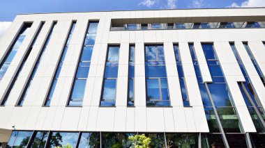 Mavi gökyüzüne karşı modern gökdelenlerin alt manzarası. Şehir merkezindeki iş binalarına bakıyorum..