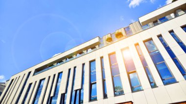 Mavi gökyüzüne karşı modern gökdelenlerin alt manzarası. Şehir merkezindeki iş binalarına bakıyorum..