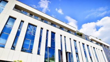 Mavi gökyüzüne karşı modern gökdelenlerin alt manzarası. Şehir merkezindeki iş binalarına bakıyorum..