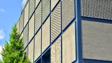 Yeşil çevresi olan modern bir endüstriyel binanın dışı. Şirket binası karbondioksiti azaltır. Eko binası.