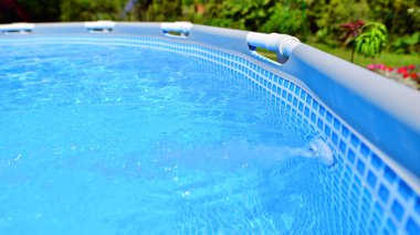 Ev ve bahçe için metal çerçeveli yüzme havuzu. Bahçedeki yüzme havuzunu çerçevele. Arka planda bahçe var. Yaz tatili eğlencesi ve eğlence.