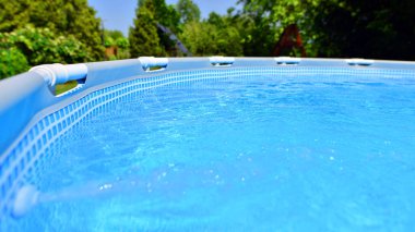 Ev ve bahçe için metal çerçeveli yüzme havuzu. Bahçedeki yüzme havuzunu çerçevele. Arka planda bahçe var. Yaz tatili eğlencesi ve eğlence.