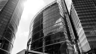 Avrupa modern ofis mimarisi. Mavi gökyüzüne karşı modern gökdelenlerin görüntüsü. Şehir merkezindeki iş binalarına bakıyorum. Siyah ve beyaz.