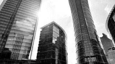 Avrupa modern ofis mimarisi. Mavi gökyüzüne karşı modern gökdelenlerin görüntüsü. Şehir merkezindeki iş binalarına bakıyorum. Siyah ve beyaz.