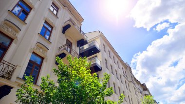 Yeşilliklerle çevrili çağdaş, çok katlı bir apartman..