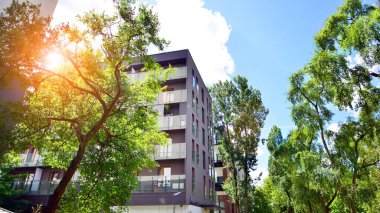 Yeşilliklerle çevrili çağdaş, çok katlı bir apartman..