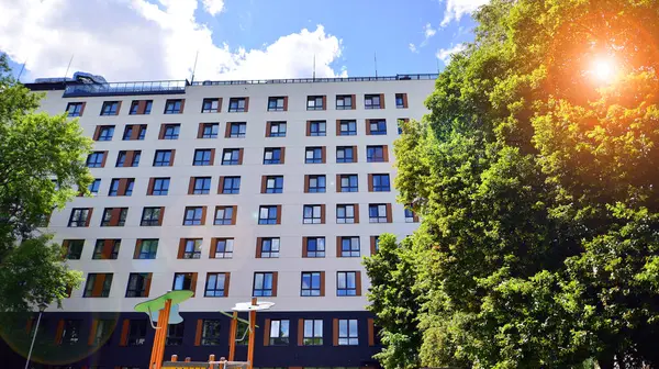 stock image A contemporary multi-story residential apartment building surrounded by lush greenery.