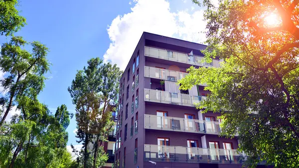 stock image A contemporary multi-story residential apartment building surrounded by lush greenery.