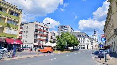 Varşova, Polonya. 9 Temmuz 2024. Şehirde yaz. Şehir merkezindeki işlek bir caddenin arka planında parlak güneş ışığıyla şehir kaldırımında yürüyen insanlar..