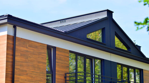 Террасные жилые дома с современным фасадом в недавно построенном жилом комплексе. Рынок недвижимости в пригороде. Новые дома с террасами в новом районе застройки.