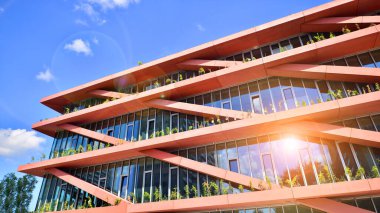 Gökyüzü arka planında cam cepheli modern ofis binası. Ofis binasının şeffaf cam duvarı.