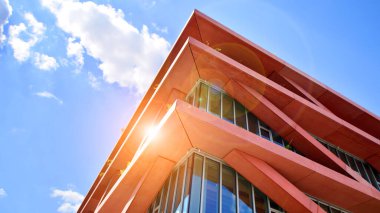 Gökyüzü arka planında cam cepheli modern ofis binası. Ofis binasının şeffaf cam duvarı.