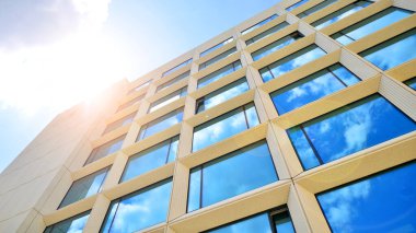 Gökyüzü arka planında cam cepheli modern ofis binası. Ofis binasının şeffaf cam duvarı.