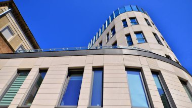 Modern bir ofis binasının cam ve kumtaşı cephesinin bir parçası. Modern bina cephesinin geniş ve soyut bir parçası. Modern cam ve taş cephe manzarası.