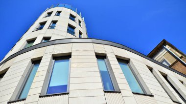 Modern bir ofis binasının cam ve kumtaşı cephesinin bir parçası. Modern bina cephesinin geniş ve soyut bir parçası. Modern cam ve taş cephe manzarası.