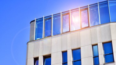 Modern bir ofis binasının cam ve kumtaşı cephesinin bir parçası. Modern bina cephesinin geniş ve soyut bir parçası. Modern cam ve taş cephe manzarası.