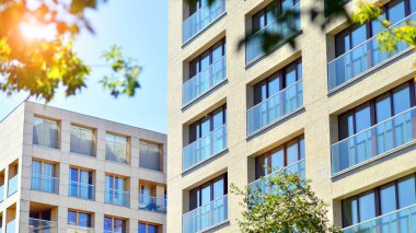 Yeşil bölgedeki yeni apartman blokları. Eko apartman binası enerji ve temiz hava tasarrufu sağlıyor. Yeşil ağaç ve yeni apartman. Doğanın ve modernliğin ahengi.