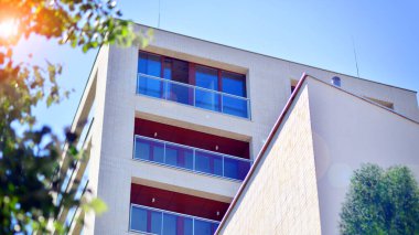 Yeşil bölgedeki yeni apartman blokları. Eko apartman binası enerji ve temiz hava tasarrufu sağlıyor. Yeşil ağaç ve yeni apartman. Doğanın ve modernliğin ahengi.