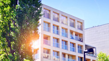 Yeşil bölgedeki yeni apartman blokları. Eko apartman binası enerji ve temiz hava tasarrufu sağlıyor. Yeşil ağaç ve yeni apartman. Doğanın ve modernliğin ahengi.