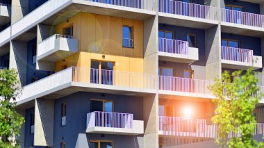 Yeşil bölgedeki yeni apartman blokları. Eko apartman binası enerji ve temiz hava tasarrufu sağlıyor. Yeşil ağaç ve yeni apartman. Doğanın ve modernliğin ahengi.