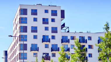 Yeşil bölgedeki yeni apartman blokları. Eko apartman binası enerji ve temiz hava tasarrufu sağlıyor. Yeşil ağaç ve yeni apartman. Doğanın ve modernliğin ahengi.