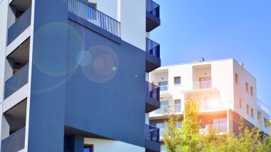 Yeşil bölgedeki yeni apartman blokları. Eko apartman binası enerji ve temiz hava tasarrufu sağlıyor. Yeşil ağaç ve yeni apartman. Doğanın ve modernliğin ahengi.