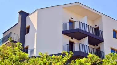 Yeşil bölgedeki yeni apartman blokları. Eko apartman binası enerji ve temiz hava tasarrufu sağlıyor. Yeşil ağaç ve yeni apartman. Doğanın ve modernliğin ahengi.