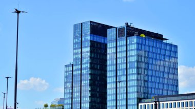 Binanın şeffaf yüzüyle cam bina ve mavi gökyüzü. Yapısal cam duvar mavi gökyüzünü yansıtıyor. Soyut modern mimari parçası. Çağdaş mimari arka plan.