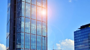 Binanın şeffaf yüzüyle cam bina ve mavi gökyüzü. Yapısal cam duvar mavi gökyüzünü yansıtıyor. Soyut modern mimari parçası. Çağdaş mimari arka plan.