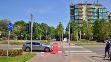 Varşova, Polonya. 24 Ağustos 2024. Las Kabacki Ormanı yakınlarındaki yaya ve araba trafiği ile bu modern konut binalarında ve geniş caddelerde Ursynow bölgesi yoğun yerleşim alanları gelişmeleri.