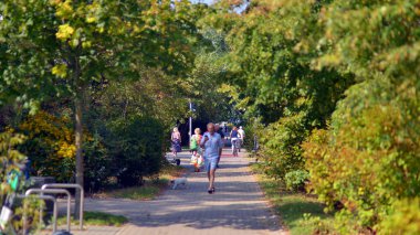 Varşova, Polonya. 24 Ağustos 2024. Ursynow 'daki parkta yürüyen sakinler