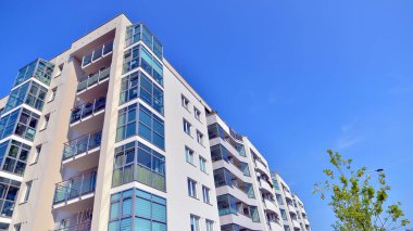 21. yüzyılın başından itibaren alçak açılı apartman binası. Apartmanın mimari unsurları. Binaların çevresi yeşildir. Ekolojik konutlar.