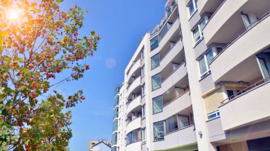 21. yüzyılın başından itibaren alçak açılı apartman binası. Apartmanın mimari unsurları. Binaların çevresi yeşildir. Ekolojik konutlar.