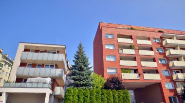 21. yüzyılın başından itibaren alçak açılı apartman binası. Apartmanın mimari unsurları. Binaların çevresi yeşildir. Ekolojik konutlar.