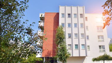 21. yüzyılın başından itibaren alçak açılı apartman binası. Apartmanın mimari unsurları. Binaların çevresi yeşildir. Ekolojik konutlar.