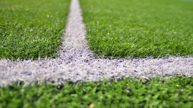 Beyaz çizgili yapay futbol sahası var. Futbol sahasında mükemmel yeşil çimlerin dokusu. 