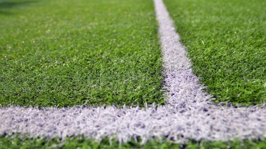 Beyaz çizgili yapay futbol sahası var. Futbol sahasında mükemmel yeşil çimlerin dokusu. 