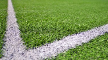 Beyaz çizgili yapay futbol sahası var. Futbol sahasında mükemmel yeşil çimlerin dokusu. 