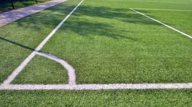 Beyaz çizgili yapay futbol sahası var. Futbol sahasında mükemmel yeşil çimlerin dokusu. 