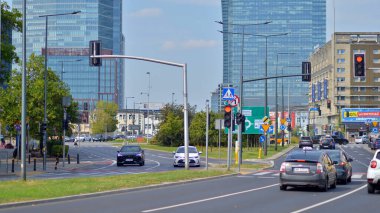 Varşova, Polonya. 25 Ağustos 2024. Araba trafiği ve şehir manzarası. Arabalar sokakta hareket ediyor. Modern binaların arka planı.