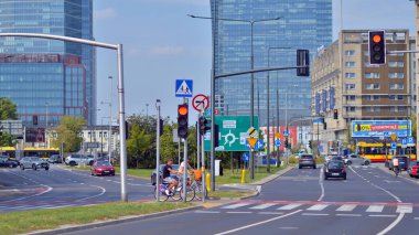 Varşova, Polonya. 25 Ağustos 2024. Araba trafiği ve şehir manzarası. Arabalar sokakta hareket ediyor. Modern binaların arka planı.