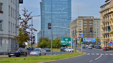 Varşova, Polonya. 25 Ağustos 2024. Araba trafiği ve şehir manzarası. Arabalar sokakta hareket ediyor. Modern binaların arka planı.