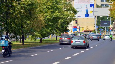 Varşova, Polonya. 25 Ağustos 2024. Araba trafiği ve şehir manzarası. Arabalar sokakta hareket ediyor. Modern binaların arka planı.