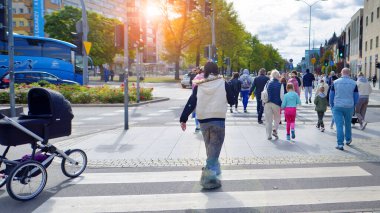 Szczecin, Polonya. 14 Eylül 2024. Şehir merkezinde güneşli bir günde ve büyük bir şehrin caddesinde. Farklı yaşlarda insanlar karşıdan karşıya geçiyor. Şehir sakinleri ve modern binaların olduğu bir cadde manzarası.